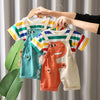 A child's two-piece outfit set featuring a striped dinosaur design in orange and green tones, displayed on a hanger.