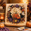 A detailed piece of pearl art featuring Halloween ghosts and pumpkins arranged in a circular wreath design.