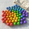 A collection of colorful plastic balls in various shades of blue, green, orange, and purple arranged in a pattern.