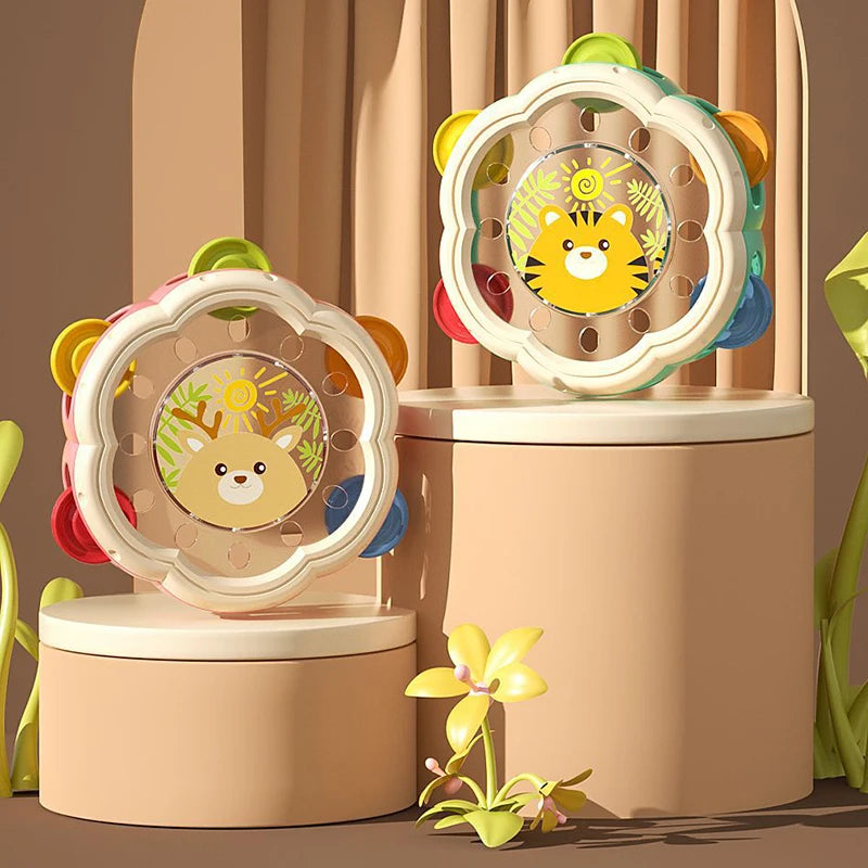 A set of baby musical instruments including a hand drum and shake rattle featuring cute animal designs.