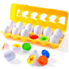 A yellow plastic egg sorter with multiple white eggs and various colored eggs for toddlers