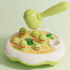 A light green Montessori animal hammer toy with a large mallet and several small, green and yellow animal figures on a beige 