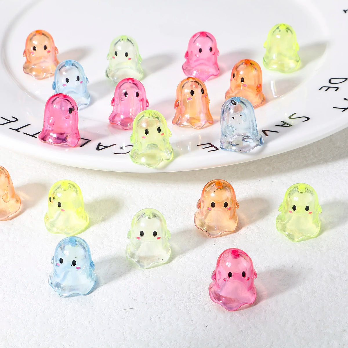 A collection of colorful acrylic ghost beads in various shades are displayed on a white plate.
