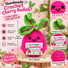 A handmade crochet cherry radish doll in pink and green with a motivational card.