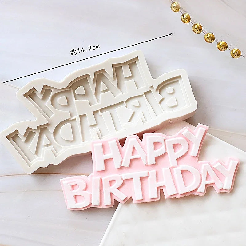 A set of white silicone cake molds shaped like 'HAPPY BIRTHDAY' and other baby-themed items.
