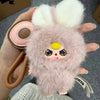 A fluffy pink bunny collectible toy with yellow accents being held by a hand.