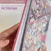 A hand holds a book titled 20 Scenes and 25 Stickers for Storage featuring isometric house designs and stickers.
