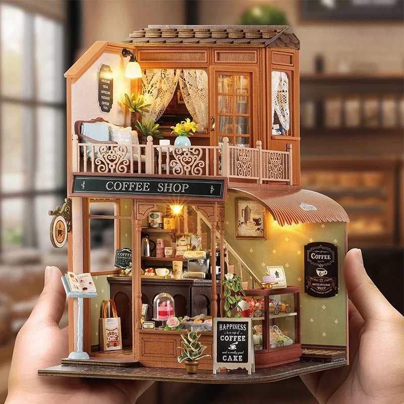 A wooden miniature dollhouse kit featuring a coffee shop facade with detailed furniture and LED lighting.
