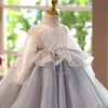 A white and gray tulle princess dress displayed on a mannequin with a gold crown.