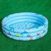 A light blue inflatable kids play pool with a cartoon design featuring fish and sea creatures resting on green turf.