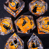 A collection of handmade liquid core resin dice set with sharp edges in various orange and clear glass shapes.