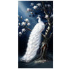 A white peacock with a crest is perched on a tree branch surrounded by magnolia blossoms against a dark blue sky.