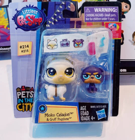 A set of three small animal figures, including a white cat, a purple dog, and a light blue creature, packaged in clear plasti