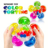 Hands hold a colorful color sorting sensory toy with various plastic pieces.