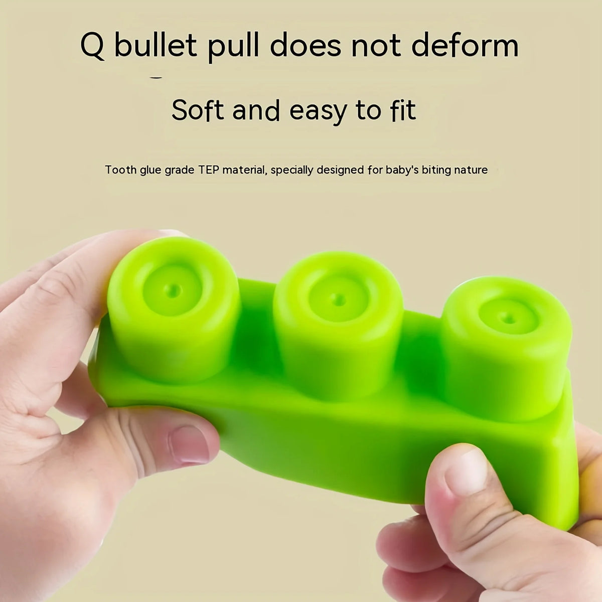 A hand holds a green silicone puzzle set with three round blocks for baby teeth practice.