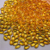 A pile of golden yellow water drop Czech glass beads for jewelry making.