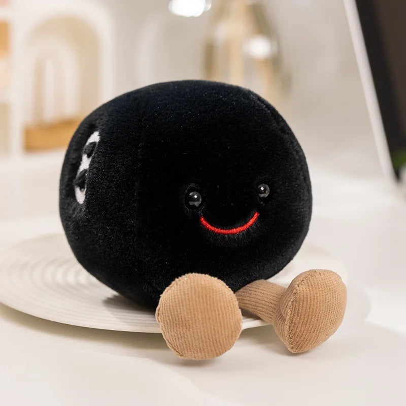 A black plush doll with a smiling face and tan limbs is resting on a white surface.