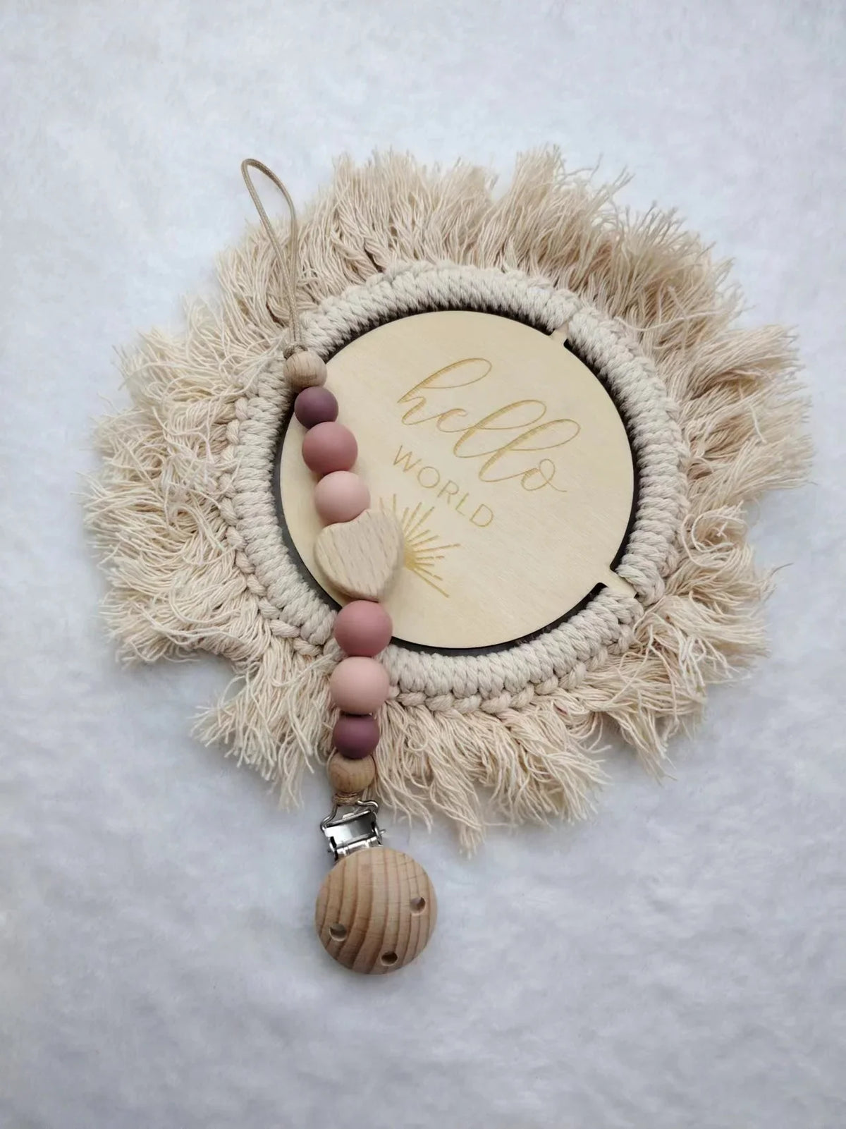 A personalized wooden baby pacifier clip featuring silicone beads and a natural fiber wreath.