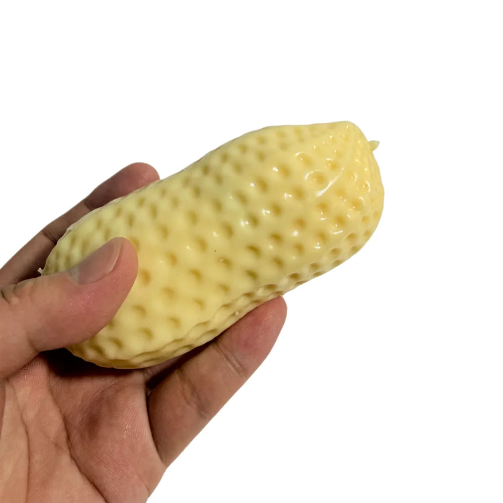 A hand is holding a yellow, bumpy peanut-shaped squishy stress ball.