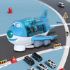 A blue toy airplane with transparent cockpit and lights flying over a gray road with traffic cones and emergency vehicles.