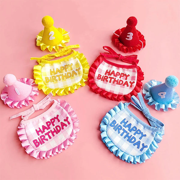 A set of colorful pet birthday hats and bibs in yellow, red, and blue for celebration.