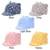 A collection of baby cotton baseball caps in blue, grey, light blue, pink, and yellow with white polka dots.