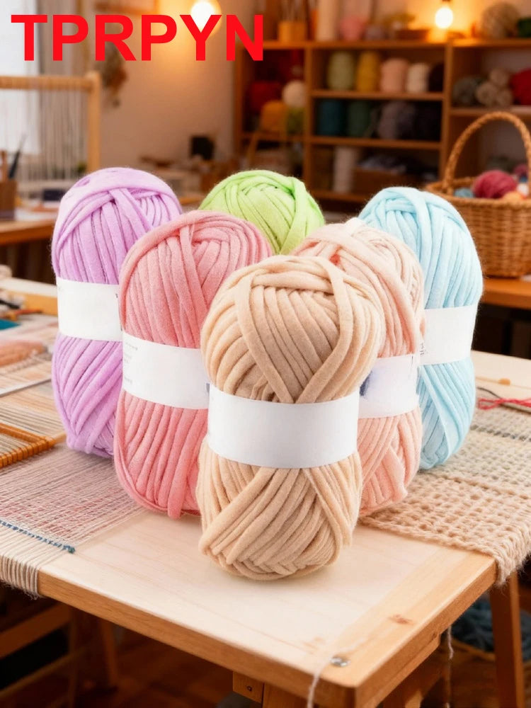 Two skeins of pink and beige chunky yarn are displayed on a wooden table.