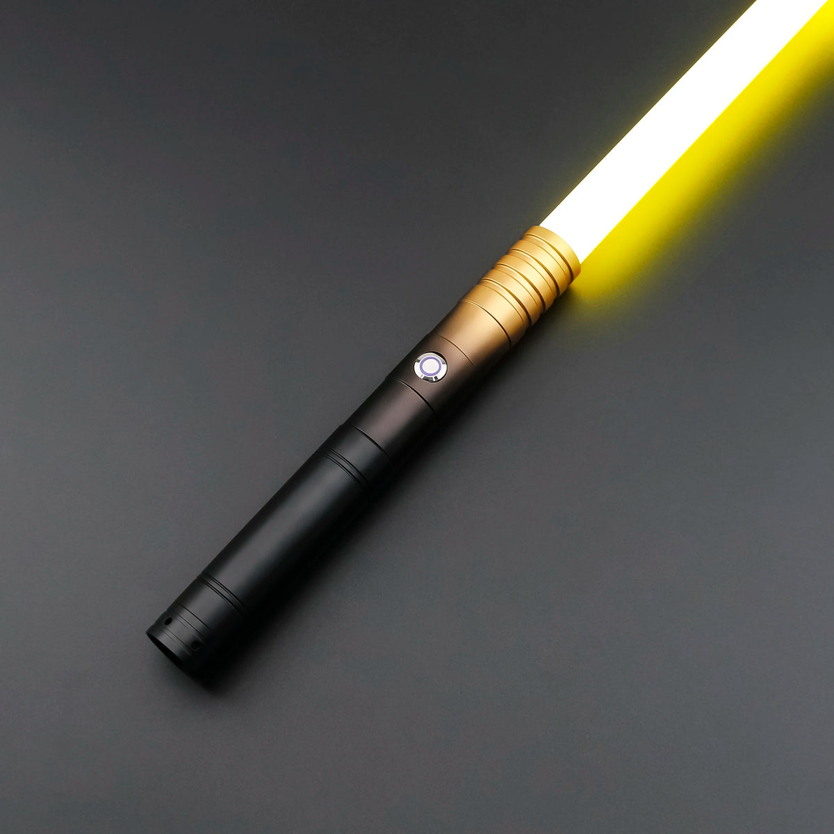 A white light saber toy with a gold metal handle and black grip, illuminated against a dark gray background.