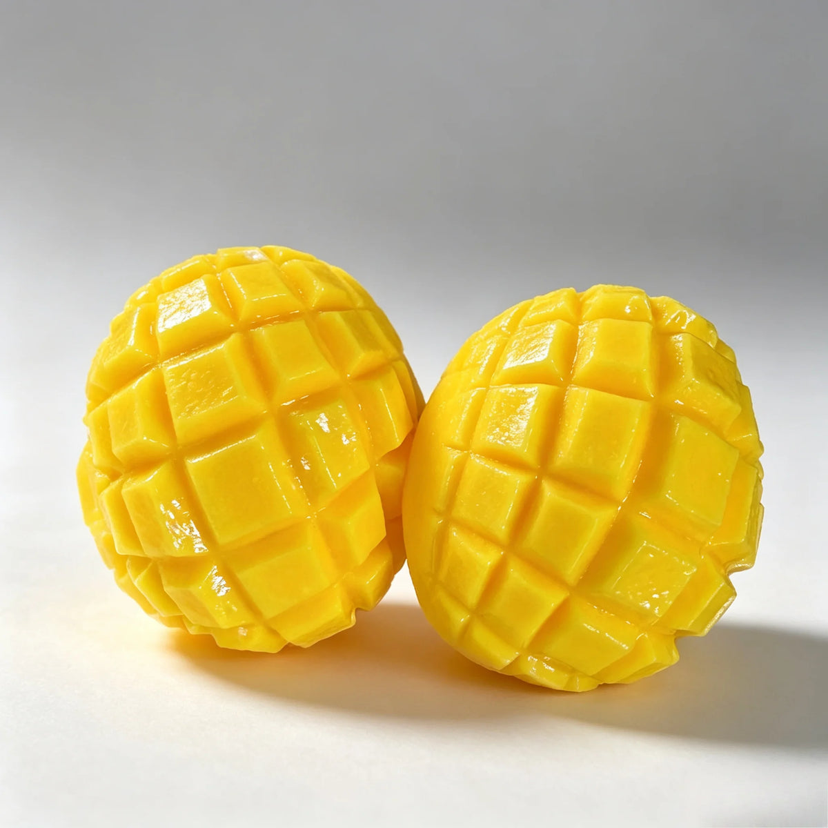 A bright yellow mango-shaped squishy stress relief ball with a textured surface is shown on a white background.