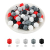 A collection of hexagonal silicone beads in red, white, gray, and black colors displayed in a white bowl.
