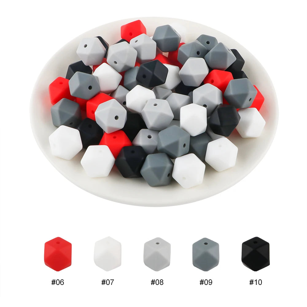 A collection of hexagonal silicone beads in red, white, gray, and black colors displayed in a white bowl.