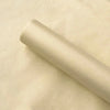 A roll of translucent tissue paper sheets lying on a light beige surface.