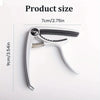 Silver aluminum alloy quick-change guitar capo with a black grip and metal pins
