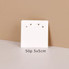 A white square jewelry display card with three holes is shown against a beige background.