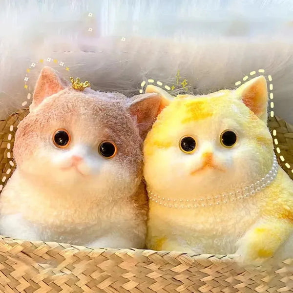 Zwei flauschige gelb-orangefarbene Katzen-Spielzeugs auf einer geflochtenen Matte.