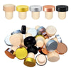 A set of ten reusable T-shaped wine bottle stoppers in various wood and metallic colors.