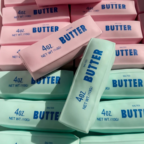 A collection of pink and white butter stick squishy fidget toys in various sizes and packaging.