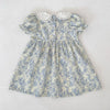 A light blue floral dress for girls featuring a gathered bodice and puff sleeves with a white lace collar.