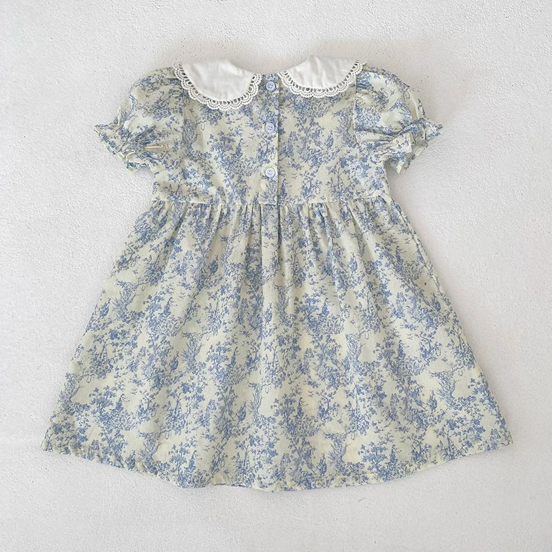 A light blue floral dress for girls featuring a gathered bodice and puff sleeves with a white lace collar.