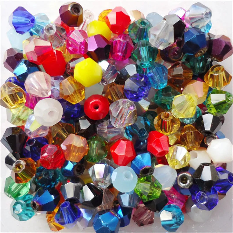 A collection of faceted glass bicone beads in various colors including red, purple, blue, green, and yellow.