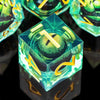 A close-up view of a green resin dice set, featuring a polyhedral die with a gold number and an eye design.