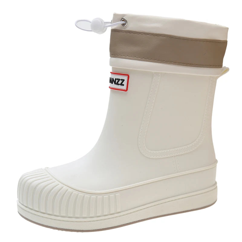 A white waterproof rain boot with a tan cuff and a small red and yellow brand tag.