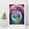 A framed diamond painting featuring a vibrant pink tree silhouette against a deep blue, starry night sky with glowing green a