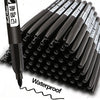 A close-up view of a black permanent fine-tip marker pen and a stack of six identical markers.