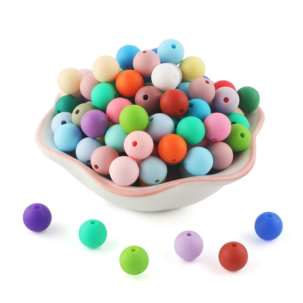 A pile of colorful silicone round beads in various shades of pink, green, yellow, and blue.