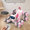 A pink remote control stunt robot dog with 8 wheels is shown on a wooden floor, being operated by a hand.
