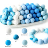 A collection of soft food-grade silicone beads in various shades of blue and white, displayed in a white dish.