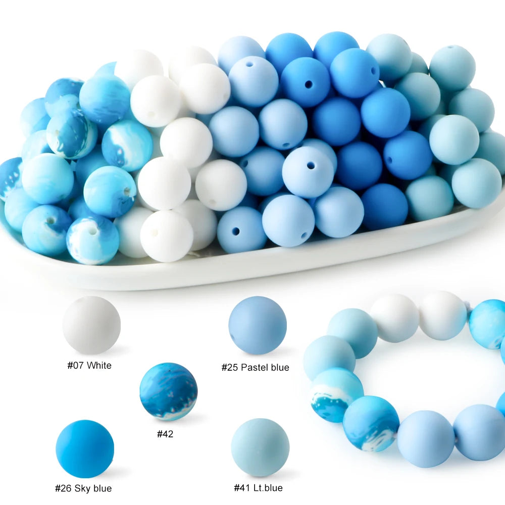A collection of soft food-grade silicone beads in various shades of blue and white, displayed in a white dish.
