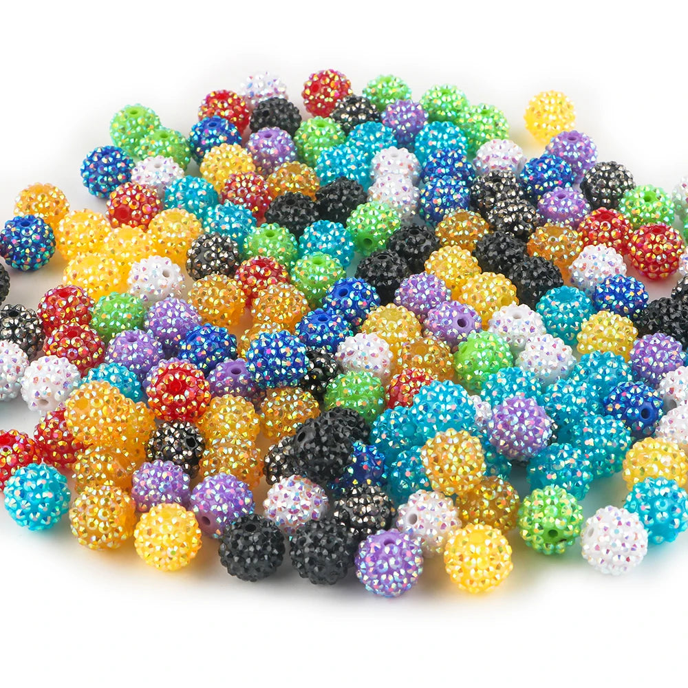 A pile of colorful rhinestone acrylic beads in various shades including red, green, blue, yellow, and black.