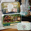 A vintage-style box theater kit featuring a wooden miniature dollhouse with furniture and decorative elements.